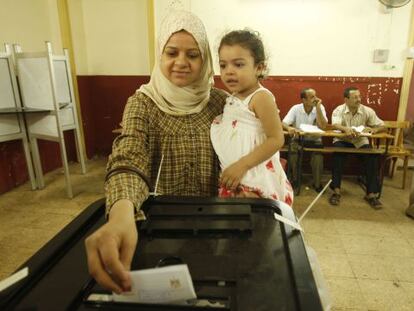 Una mujer vota con su hija en brazos en El Cairo.