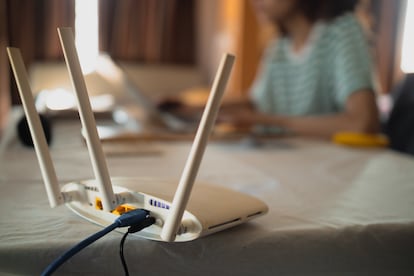 Una mujer trabaja desde casa con sus dispositivos conectados a una red wifi.