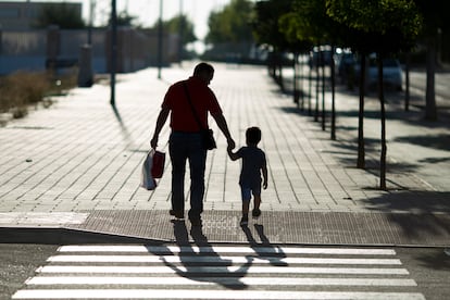 Un niño junto a su padre camina hacia el colegio en el primer día del curso escolar.