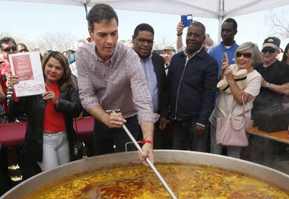 Pedro Sánchez remueve una paella al término del acto de su candidatura en Santos de la Humosa.