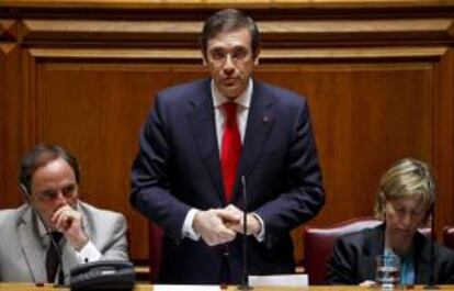 El primer ministro de Portugal, Pedro Passos Coelho (c), pronuncia un discurso en compañía del ministro de Exteriores, Paulo Portas (i) y la ministra de Finanzas, Maria Luis Albuquerque (d), durante el debate del Estado de la Nación en el Parlamento en Lisboa (Portugal). EFE/Archivo