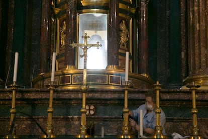 Isabel limpia los elementos del altar de la basílica del Monasterio de El Escorial.