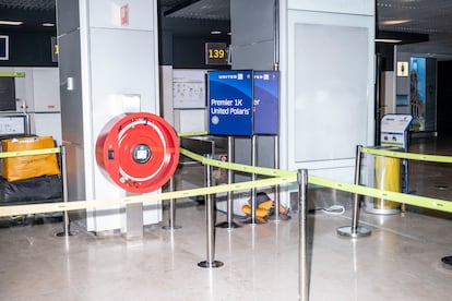 Una persona duerme en los pasillos que conectan la terminal 1 y 2 de Barajas durante la madrugada del lunes. 