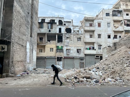 Un joven acarrea provisiones ante un edificio destrozado por los bombardeos del rgimen en el barrio de Kalaseh, uno de los ms castigados durante la batalla por el control de Alepo entre 2012 y 2016