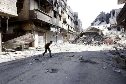 Un hombre cruza la calle en el campo de refugiados de Yarmuk, en Damasco, la capital siria.