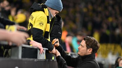 Edin Terzic, entrenador del Borussia Dortmund, firma un autógrafo a un joven aficionado del conjunto alemán en el Westfalenstadion.