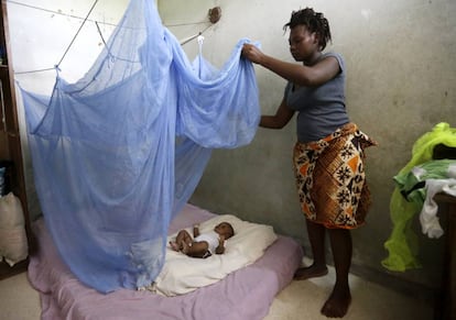 Una mujer cubre a su hijo con una mosquitera en Costa de Marfil para protegerle de la malaria.