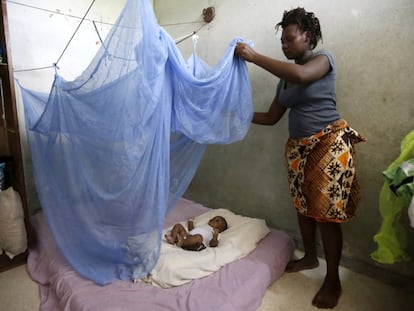 Una mujer cubre a su hijo con una mosquitera en Costa de Marfil para protegerle de la malaria.