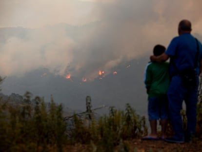 Un hombre y su hijo observan el incendio forestal declarado en la sierra Bermeja (Málaga) que ha obligado a desalojar a medio millar de personas. / GARCÍA-SANTOS