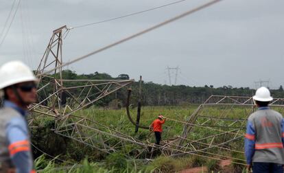 Técnicos ao lado de torre de transmissão de energia destruída no Ceará.