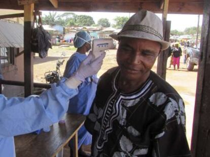 Un sanitario le toma la temperatura a un hombre en Ganta (Liberia).