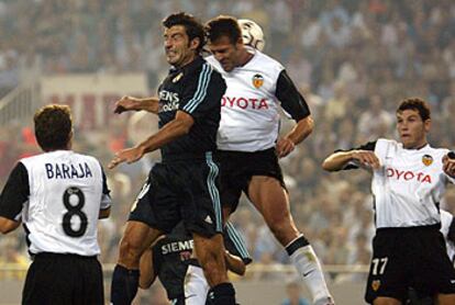 Figo y Marchena saltan para cabecear la pelota en el partido que ha enfrentado en Metalla al Valencia y el Madrid