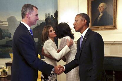 La primera dama, Michelle Obama (en segundo plano) besa a la reina Letizia, mientras el Rey Felipe VI estrecha la mano del presidente de Estados Unidos Barack Obama a su llegada a la Casa Blanca, durante el primer día de su visita a Washington (EE UU).