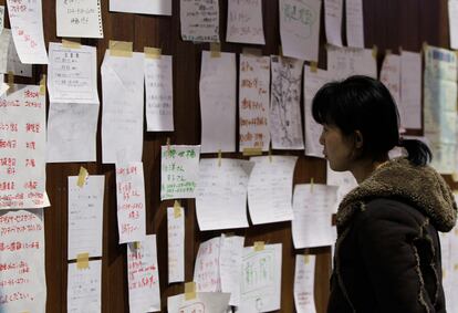 Una mujer mira los mensajes colgados en un panel colocado en un gimnasio de Kawamata, convertido en un centro de refugiados para los desplazados por el accidente nuclear de Fukushima.