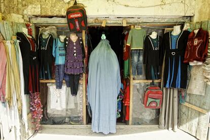 Una mujer cubierta por el burka entra en una tienda en Qala-i-Naw.