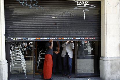 Un café del paseo de Gràcia con la persiana medio bajada.