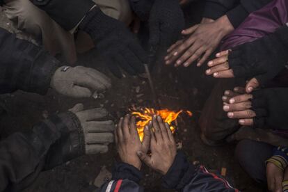 Iraquíes desplazados se calientan, en un campamento cerca de Mosul (Irak).