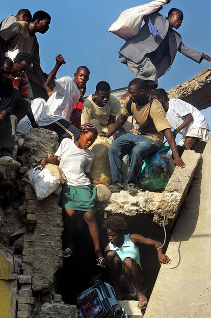 Un grupo de haitianos huye por los tejados de las tiendas con su botín.