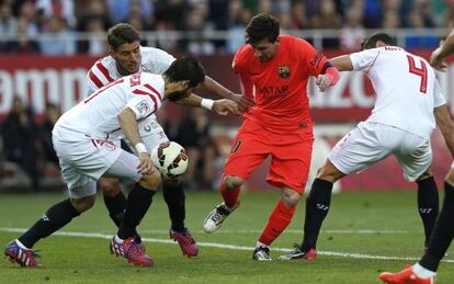 Messi trata de controlar el balón rodeado de jugadores del Sevilla.