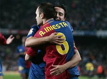 Iniesta y Xavi se abrazan durante un partido de la pasada temporada.