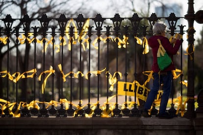 Una mujer coloca lazos amarillos en la verja del Pac de la Ciutadella, en el Paseo de Lluís Companys, donde la ANC ha instalado una pantalla gigante para seguir en directo la sesión constitutiva de la cámara catalana surgida de las elecciones del 21-D. 
