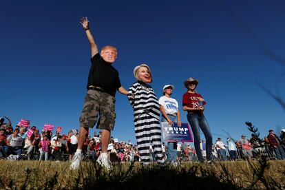 Un hombre disfrazado de Donald Trump sosteniene a su mujer disfrazada de Hillary Clinton prisionera, mientras sus hijas apoyan la campaña de Trump en Naples, Florida (EE UU), el 23 de octubre.