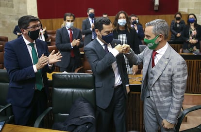 El presidente andaluz, Juanma Moreno (centro) felicita al consejero de Hacienda, Juan Bravo (derecha), ante el vicepresidente, Juan Marín (izquierda), este miércoles.