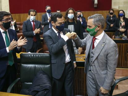 El presidente andaluz, Juanma Moreno (centro) felicita al consejero de Hacienda, Juan Bravo (derecha), ante el vicepresidente, Juan Marín (izquierda), este miércoles.