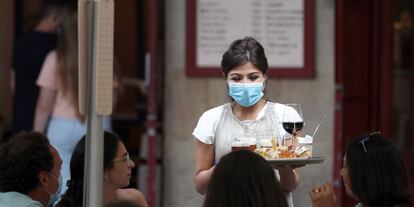 Una camarera atiende a unos turistas este martes en Bilbao.