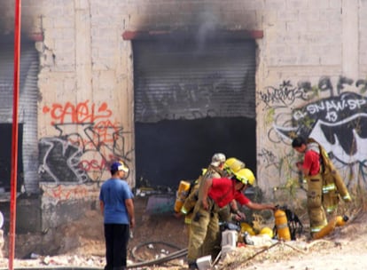 Miembros del cuerpo de bomberos trabajan en la fábrica de neumáticos donde se inició el incedio.