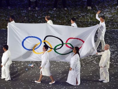 Silva saluda mientras porta la bandera ol&iacute;mpica junto a otras personalidades.