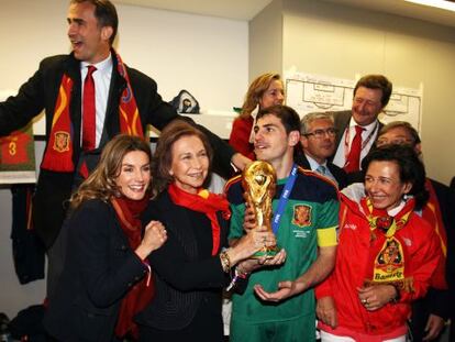 Don Felipe, con doña Letizia y doña Sofía, detrás de Casillas, capitán de la selección nacional de fútbol en el vestuario tras la victoria de España en Sudáfrica en 2010.