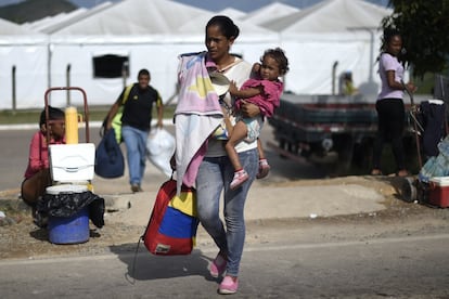 Una mujer sostiene en brazos a su hija mientras cruza la frontera entre Venezuela y Brasil, el 23 de agosto de 2018. La diáspora de los venezolanos se perfila como la mayor de Latinoamérica en los últimos 50 años. De acuerdo con cifras de las Naciones Unidas, más de tres millones de personas se han ido del país en años recientes y se estima que la cifra aumente a más de cinco millones para finales de 2019. Venezuela es un país en el que diariamente 5.000 personas recogen sus pertenencias para huir del colapso económico y la crisis humanitaria que agobia a la nación. Solo a España han emigrado más de 200.000 personas, de acuerdo con cifras de la Organización Internacional de Migraciones de la ONU en 2018, esto sin contar aquellos en situación irregular o venezolanos con nacionalidad europea.