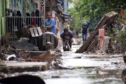 Personas regresan a sus viviendas para limpiarlas tras las inundaciones que dejó a su paso Iota, en la localidad de La Lima, departamento de Cortés (Honduras). La región norte de Honduras continúa en tareas de limpieza de montañas de lodo y todo tipo de basura, y la reactivación del quehacer productivo, ocho días después de que la tormenta tropical Iota salió del país dejando decenas de muertos y millonarias pérdidas a la infraestructura aún no cuantificadas.