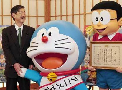 El ministro de Exteriores, Masahiko Komura, con el gato-robot <i>Doraemon</i> y Nobita.