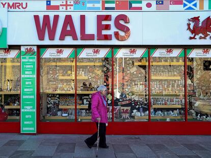 Una mujer con pantalla facial protectora camina por el centro de Cardiff, en Gales.