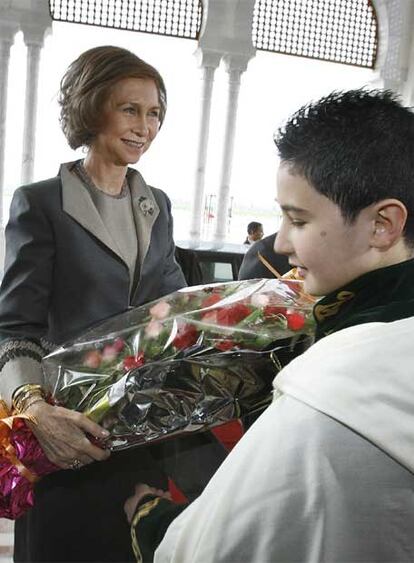 La reina Doña Sofía recibe un ramo de flores a su llegada al aeropuerto de Argel. Un niño argelino ha sido el encargado de entregárselo. Los Reyes tratarán diferentes cuestiones en este viaje de Estada, entre ellas la situación del Sáhara.