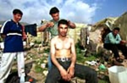Un inmigrante marroquí le corta el pelo a un compañero en un poblado de chabolas de El Ejido.