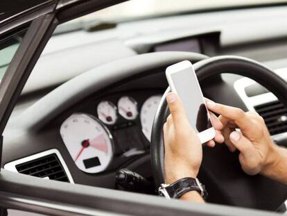 Un conductor usa el teléfono móvil al volante, en una imagen de archivo.