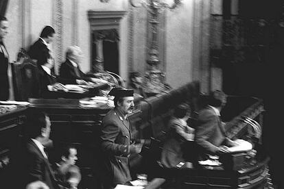 En la tarde del 23 de febrero de 1981 se producía el <i>arresto</i> del Gobierno y del Parlamento democráticos. En la foto, Tejero sube las escaleras de la tribuna  y llega a la presidencia mientras otros asaltantes toman posiciones.