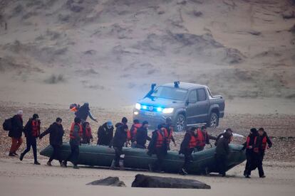 Un grupo de más de 40 inmigrantes carga con un bote neumático este miércoles desde Francia con rumbo a Reino Unido