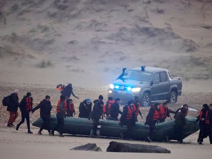Un grupo de más de 40 inmigrantes carga con un bote neumático este miércoles desde Francia con rumbo a Reino Unido