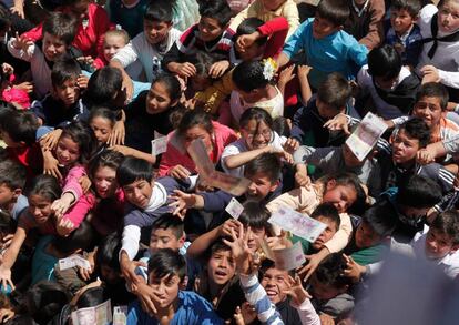 Niños saltan para alcanzar billetes lanzados por los católicos desde la torre de la iglesia, en gratitud por los favores recibidos por la Vírgen, en Guarambaré (Paraguay).