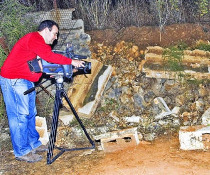 Un cámara de televisión toma imágenes del muro que cayó sobre los niños.