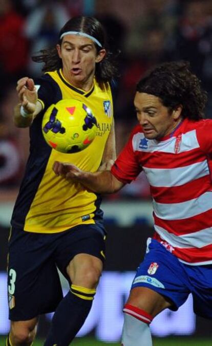 Filipe Luis disputa un balón con Iturra, del Málaga.