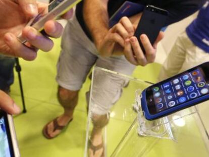 Varias personas prueban tel&eacute;fonos en una tienda de Madrid