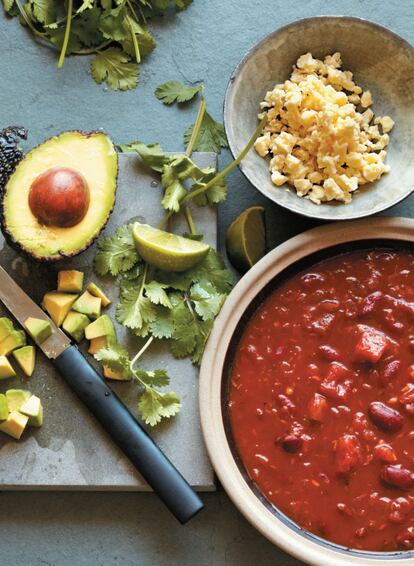 <p><b>El chipotle,</b> tipo de chile jalapeño ahumado y seco, le da a esta sopa un sabor picante intenso. Queda estupenda con una salsa de pico de gallo y los totopos caseros. El aguacate y un queso firme y cremoso ayudan a atenuar el ardor.</p><p><i>Ingredientes</i></p><p> Para 4 personas: 1 cebolla roja pelada y cortada en daditos, 2 cucharaditas de semillas de comino tostadas, 1 cucharadita de orégano seco, 2 dientes de ajo pelados y picados, 2-4 chiles chipotles secos finamente picados, 1 cucharada de puré de tomate concentrado, 400 gramos de tomates troceados en lata, 400 gramos de frijoles cocidos, 1 cucharadita de azúcar, 500-750 mililitros de caldo de verduras o de pollo, 100 gramos de queso de vaca semicurado, 1 aguacate maduro pelado y picado, ½ taza de cilantro troceado, aceite de oliva, sal y pimienta.</p><p><i> Preparación</i></p><p> 1. Poner una cazuela a fuego medio con un chorrito de aceite de oliva. Una vez caliente, sofreír la cebolla con una pizca de sal y pimienta. 2. Añadir las semillas de comino y el orégano y freír 2 minutos más, o hasta que las semillas desprendan su aroma. Añadir el ajo y los chiles secos, sofreír 2 minutos más y agregar el puré de tomate. 3. Revolver sobre el fuego 1 o 2 minutos y agregar los tomates y los frijoles junto con el azúcar. Removerlos y, cuando hiervan, añadir 500 mililitros de caldo. 4. Llevar a ebullición, reducir el fuego y cocer la sopa a fuego lento entre 10 y 15 minutos, hasta que espese ligeramente. 5. Añadir un poco más de caldo si se solidifica demasiado. Verter la sopa en cuencos calientes y esparcir por encima el queso, el aguacate y el cilantro.</p>