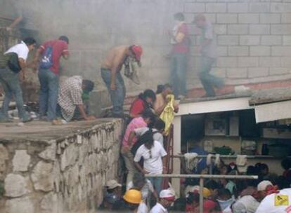 Las fuerzas de seguridad lanzan gases lacrimógenos a los simpatizantes de Zelaya afuera de la embajada de Brasil en Tegucigalpa