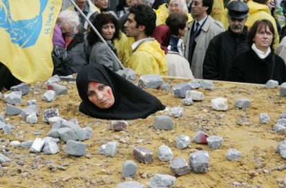 Una mujer iraní simula una lapidación en Bruselas en señal de protesta.