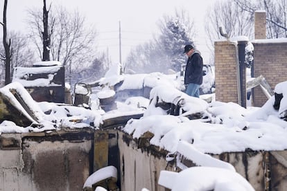 Daniel Peers mira a travs de los restos cubiertos de nieve de las casas quemadas despus del incendio forestal de Marshall, el 1 de enero de 2022, en Louisville, Colorado.